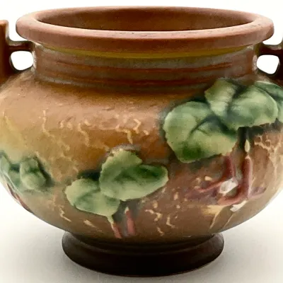 Sale Photo Thumbnail #16: Roseville Pottery Fuchsia pattern two-handled urn or vase, featuring embossed green leaves and pink fuchsia blossoms on a textured brown and gold background, circa 1938.