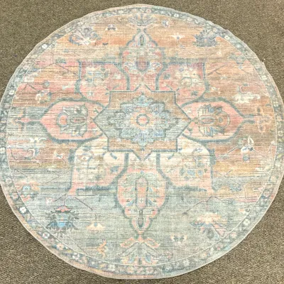 Sale Photo Thumbnail #12: Round area rug featuring a distressed traditional Persian-style medallion pattern in muted shades of blue, pink, and beige.