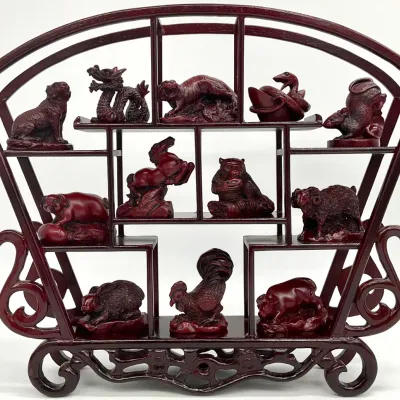 Sale Photo Thumbnail #51: Chinese zodiac figurine set featuring twelve red resin animal figures displayed on a matching fan-shaped wooden curio stand.