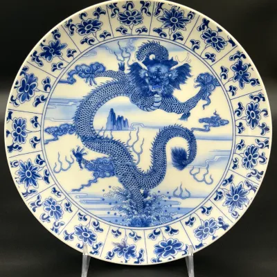 Sale Photo Thumbnail #69: Chinese blue and white porcelain charger plate featuring a detailed central dragon motif surrounded by a floral border.