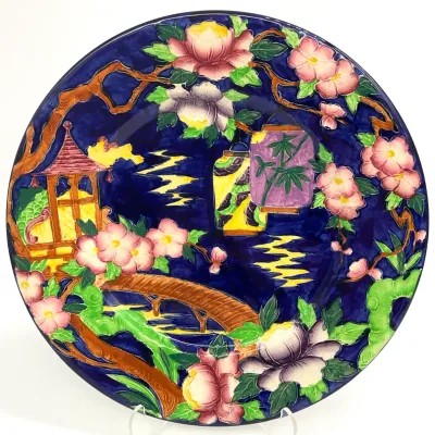 Sale Photo Thumbnail #43: Carlton Ware hand-painted ceramic charger in the 'Mikado' pattern, featuring a vibrant Chinoiserie scene with a pagoda, bridge, and lanterns on a deep cobalt blue ground.
