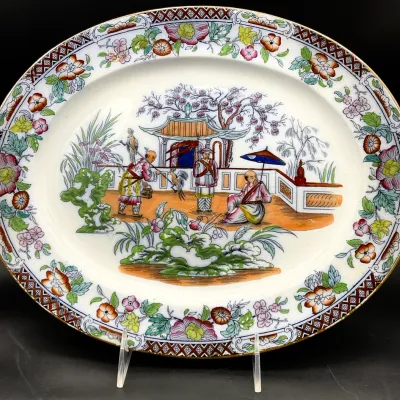 Sale Photo Thumbnail #36: Antique English ironstone oval platter in a Chinoiserie pattern, featuring hand-painted figures in a garden setting with a floral border.