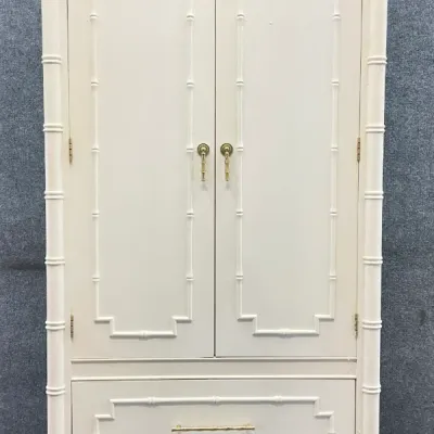 Sale Photo Thumbnail #4: Vintage white faux bamboo armoire featuring two upper doors, two lower drawers with brass hardware, and decorative finials, in the Hollywood Regency style.