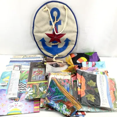 Sale Photo Thumbnail #47: Assortment of decorative garden flags and a nautical-themed burlap door hanger featuring a blue anchor and red star.