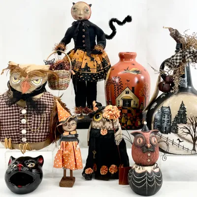 Sale Photo Thumbnail #56: Collection of folk art Halloween decorations, including handmade fabric dolls, painted gourds, and a ceramic black cat dish.