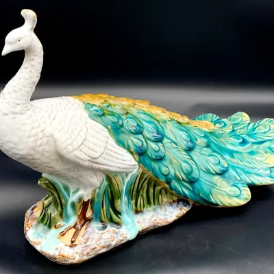Sale Photo Thumbnail #76: Vintage Italian majolica ceramic peacock figurine, featuring a white body with vibrant turquoise, green, and gold glazed tail feathers.