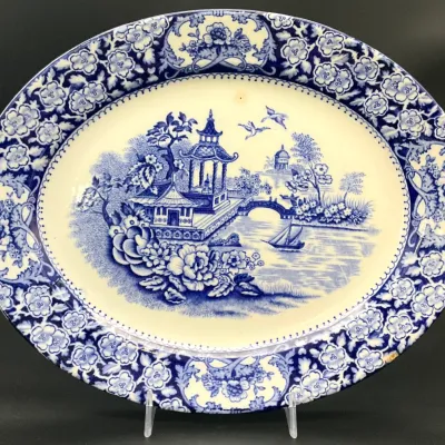 Sale Photo Thumbnail #68: Vintage blue and white transferware oval platter featuring a classic Chinoiserie landscape scene with a floral border.