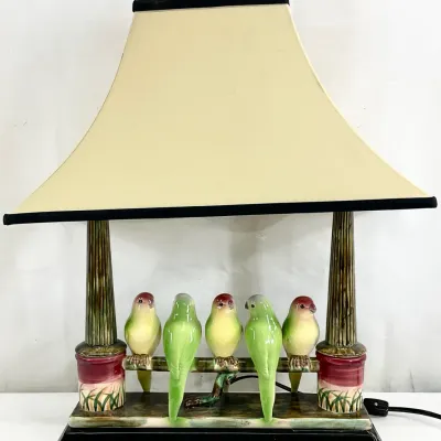Sale Photo Thumbnail #97: Vintage ceramic table lamp featuring five green and yellow lovebirds perched on a branch, complete with a flared cream-colored shade.
