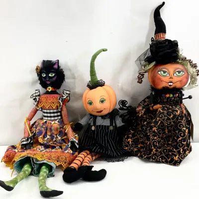 Sale Photo Thumbnail #59: Trio of whimsical Halloween art dolls, including a black cat in a colorful dress, a small pumpkin child in overalls, and a pumpkin witch in an ornate black and gold gown.