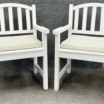 Sale Photo Thumbnail #41: Pair of white-painted wooden patio armchairs featuring slatted backs and patterned beige and white seat cushions.
