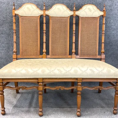 Sale Photo Thumbnail #17: Vintage three-back settee featuring cane panels, turned wood posts, and cream-colored damask upholstery on the seat and crests.