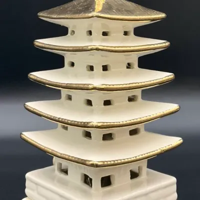Sale Photo Thumbnail #63: Vintage white ceramic five-story pagoda figurine featuring gold-gilded accents on the roofs, spire, and base.