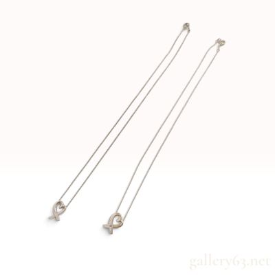 A Pair of Tiffany and Co. Paloma Picasso Sterling Silver Loving Heart Pendants