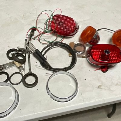An Assortment of Vintage Motorcycle Lighting and Mechanical Components