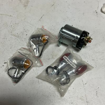 A Set of Motorcycle Electrical Components Including Starter Solenoid and Chrome Bullet Lights