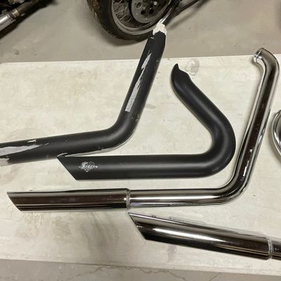 A Collection of Motorcycle Exhaust Pipe Components Including Vance and Hines