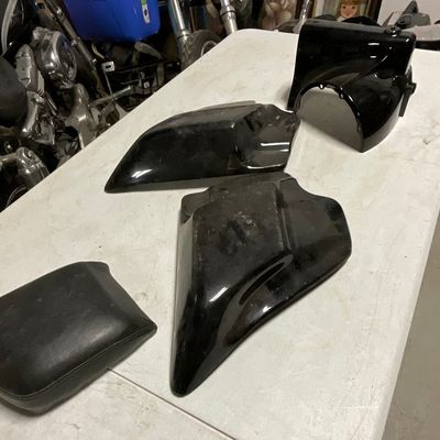 A Group of Harley-Davidson Sportster Body Components and Seat Pad Including Part 67674-03A