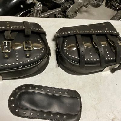 A Trio of Studded Leather Motorcycle Saddlebags and Fender Bib