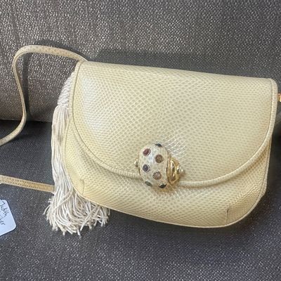 Vintage Judith Leiber off-white lizard skin evening bag featuring a long shoulder strap, side tassel detail, and a jewel-encrusted...
