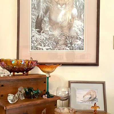 Assorted glassware and framed art, including a large framed print of a cougar in a snowy forest, amber carnival glass bowls, and small...