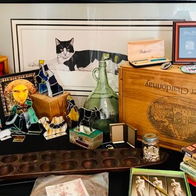 Eclectic collection of home decor and collectibles, featuring a wooden mancala board, a Beringer Chardonnay wooden crate, stained glass...