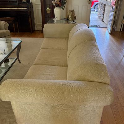 Sale Photo Thumbnail #78: Contemporary three-cushion sofa with rolled arms and textured beige fabric upholstery, shown in a living room setting.