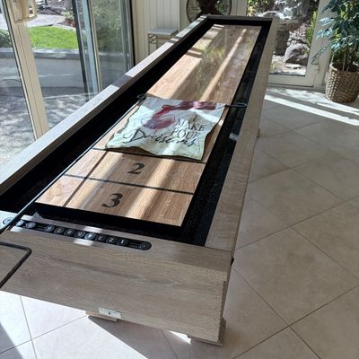 Sale Photo Thumbnail #64: Modern shuffleboard table with a light wood finish, glossy playing surface, and integrated manual abacus scorers.