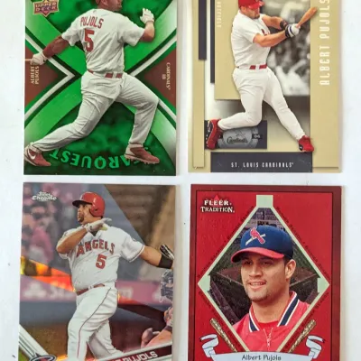 Four Albert Pujols baseball cards, including an Upper Deck Starquest, Playoff Prestige, Topps Chrome, and Fleer Tradition.