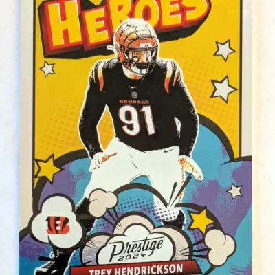 2024 Panini Prestige Trey Hendrickson "Heroes" insert trading card, featuring a comic book-style design with the Cincinnati...