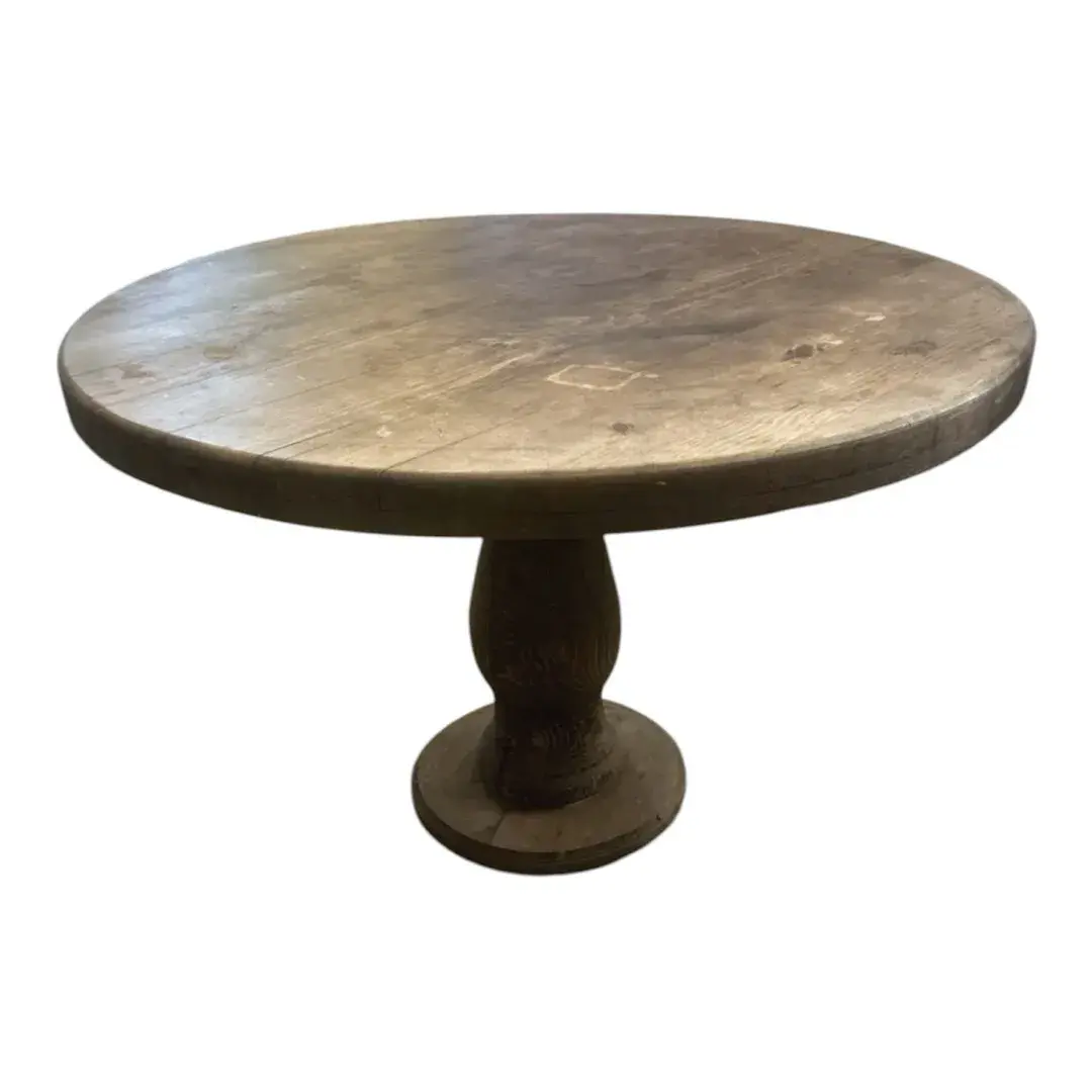 Round wooden pedestal table featuring a rich dark finish and a distinctively turned, carved pillar b