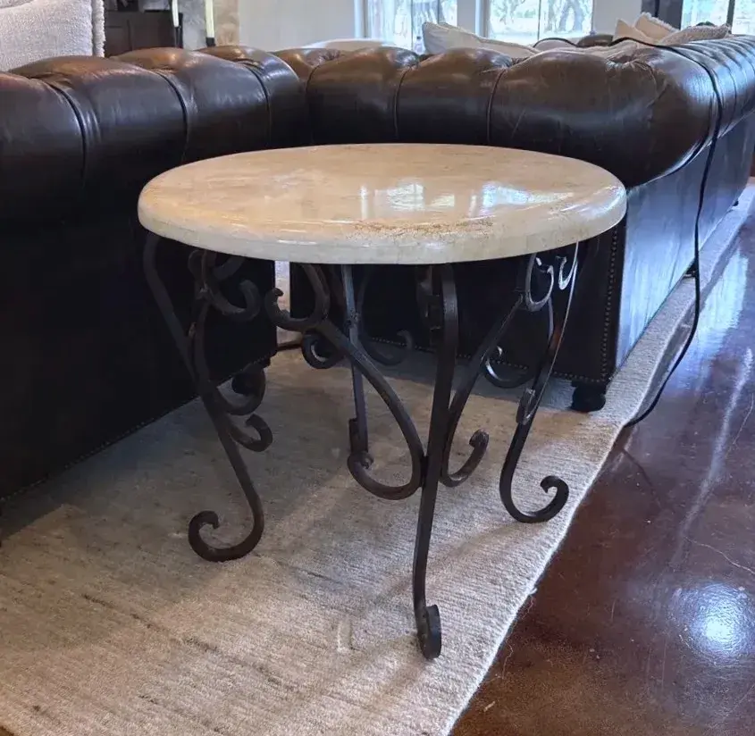 Round side table with smooth beige stone top with scrollwork 