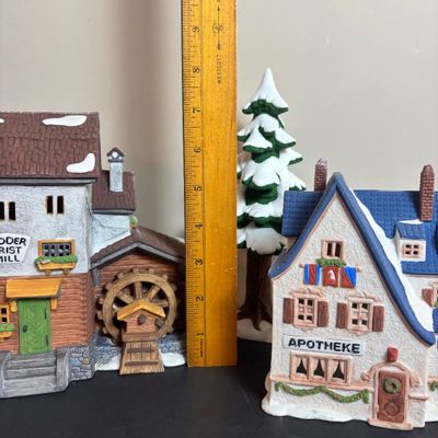 LOT 97: Dept 56 Alpine Village Series: Stoder Grist Mill, Apotek & Tabak along with a Village Porcelain Pine Tree