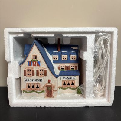 LOT 97: Dept 56 Alpine Village Series: Stoder Grist Mill, Apotek & Tabak along with a Village Porcelain Pine Tree