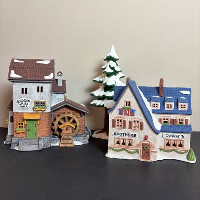 LOT 97: Dept 56 Alpine Village Series: Stoder Grist Mill, Apotek & Tabak along with a Village Porcelain Pine Tree