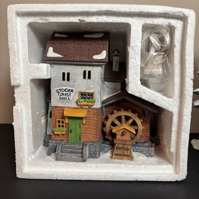 LOT 97: Dept 56 Alpine Village Series: Stoder Grist Mill, Apotek & Tabak along with a Village Porcelain Pine Tree