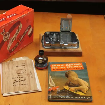 Vintage Mansfield Auto-Splice film splicer with its original box, a bottle of Cine Film Cement, a Bell & Howell Filmo 8mm camera...