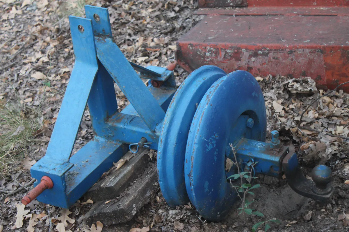 Sale Photo Thumbnail #54: Blue painted three-point hitch attachment with a trailer ball and heavy-duty dual pulleys, showing some wear and rust from outdoor storage.
