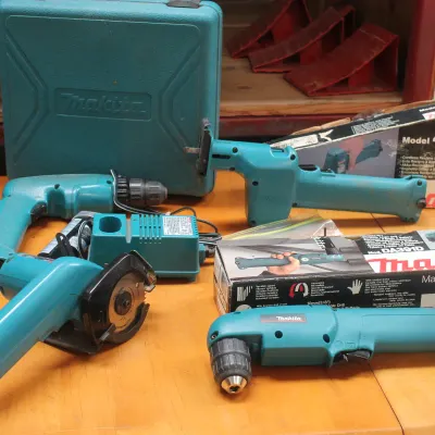 Collection of vintage Makita 9.6V cordless power tools, including a drill, circular saw, reciprocating saw, and right-angle drill, some...