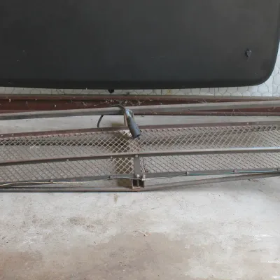 Hitch-mounted steel mesh cargo carrier featuring integrated red taillights and wiring.