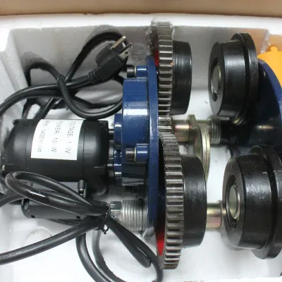Electric trolley hoist motor assembly with power cord and wired remote control, stored in its original styrofoam packaging.