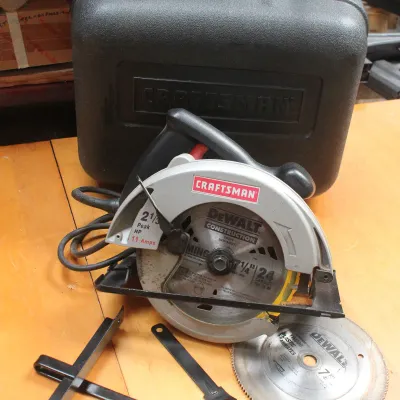 Craftsman 7-1/4 inch circular saw with an 11-amp motor, shown with its black plastic carrying case, an extra DeWalt blade, and guide...