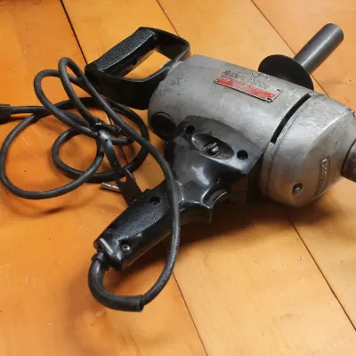 Vintage Craftsman heavy-duty 1/2-inch electric drill with a metal body, spade handle, and side auxiliary handle.