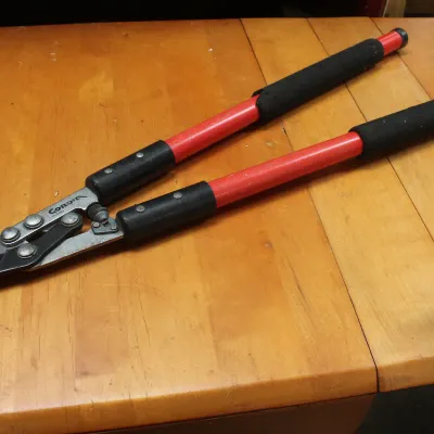 Corona bypass loppers with red handles and black foam grips, showing light wear from use.