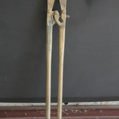 Vintage heavy-duty bolt cutters with long metal handles and black rubber grips, showing some wear and patina from use.