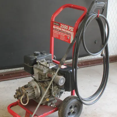 Ex-Cell 2500 PSI gas-powered high pressure washer on a red wheeled cart, complete with hose and spray wand.