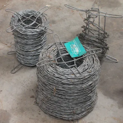 Three rolls of galvanized barbed wire on wire carriers, including one large full roll with an Oklahoma Steel & Wire tag, one medium...