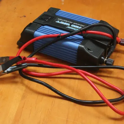 Power Bright 750-watt power inverter in blue and black casing, complete with red and black battery clamp cables.