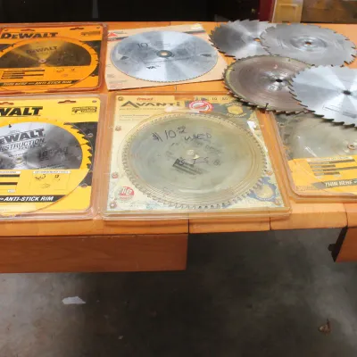 Assortment of 10-inch circular saw blades, including DeWalt and Freud Avanti brands, some in original packaging and others loose.