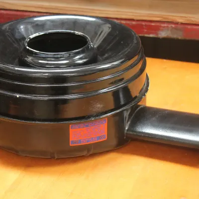 Vintage AC heavy duty oil bath air cleaner assembly in gloss black finish, featuring an original orange and blue decal.
