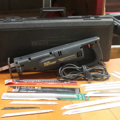 Sears Craftsman electronic reciprocating saw with its original black plastic carrying case and an assortment of replacement blades.
